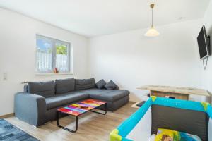 ein Wohnzimmer mit einem Sofa und einem Spieltisch in der Unterkunft Ferienwohnung Eyrich Eg in Lindau