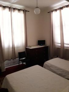 1 dormitorio con 2 camas y escritorio con ordenador portátil en Pensao Residencial Mirasol, en Funchal