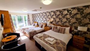 a hotel room with two beds and a window at Farnham House Hotel in Farnham