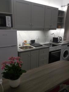 a kitchen with white cabinets and a sink and a table at studios FLORA in naoussa paros in Naousa