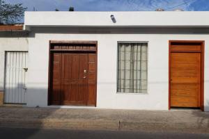 een wit huis met twee houten deuren erop bij Apartament, the best location, 60 mts from the sea in Cozumel
