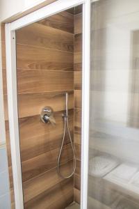 um chuveiro na casa de banho com uma parede de madeira em Garda Fantasy Apartment - JACUZZI em Desenzano del Garda