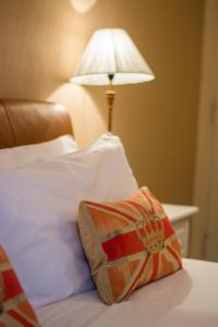 a pillow sitting on top of a bed with a lamp at Beachlands Hotel in Weston-super-Mare