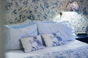 a bed with blue and white pillows on it at Beachlands Hotel in Weston-super-Mare
