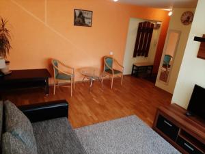 a living room with chairs and a glass table at Holiday Apartment in Liepāja +2 photos