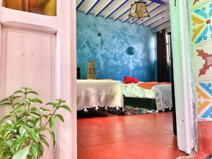 una camera con due letti e pareti blu di Riad Beldy a Essaouira