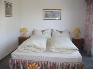 sypialnia z łóżkiem z białymi poduszkami w obiekcie Apartment A'Horn w mieście Sankt Johann in Tirol