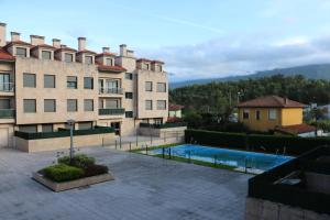 uma vista para um edifício e uma piscina em Diañu, apartamento con Piscina en Llanes em Llanes