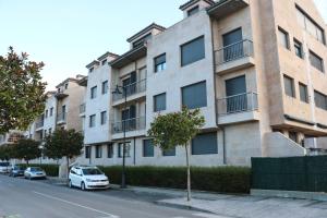 Diañu, apartamento con Piscina en Llanes في يانس: سيارة بيضاء متوقفة أمام مبنى