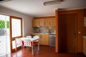 a kitchen with a table and some chairs and a table at Snooker House in Ponta Delgada