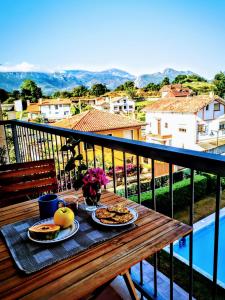 stół z talerzami jedzenia na balkonie w obiekcie Diañu, apartamento con Piscina en Llanes w mieście Llanes