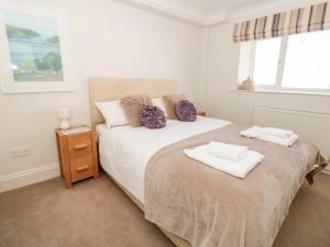 a bedroom with a bed with two towels on it at Huffin in Dartmouth