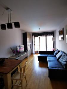 uma sala de estar com um sofá azul e uma mesa em Diañu, apartamento con Piscina en Llanes em Llanes