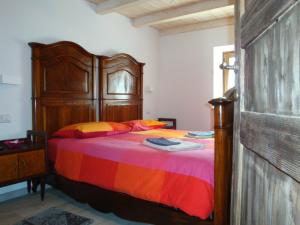 SantʼAnna dʼAlfaedo的住宿－Da Andrea e Raffaella，一间卧室配有一张大床和木制床头板