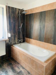 Das Bad ist mit einer Badewanne und einer Dusche ausgestattet. in der Unterkunft Charmante 3Zi-Ferienwohnung im Landhausstil in Kaufbeuren