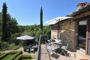 patio con tavolo, sedie e ombrellone di I Cipressi a Castelnuovo Berardenga