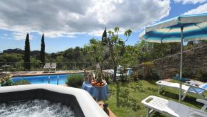 un jardín con bañera de hidromasaje junto a una piscina en Ricetro, en Camaiore