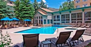 a swimming pool with chairs and a building at GetAways at Falcon Point Resort in Avon