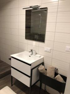 a white bathroom with a sink and a mirror at Apartment Šelih in Maribor