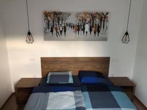 una camera da letto con un letto e un dipinto sul muro di Apartment Šelih a Maribor