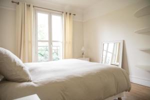パリにあるRomantic Nestの白いベッドルーム(大型ベッド1台、窓付)