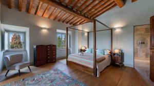 a bedroom with a canopy bed and a chair at Palazzone in Torrita di Siena +48 photos