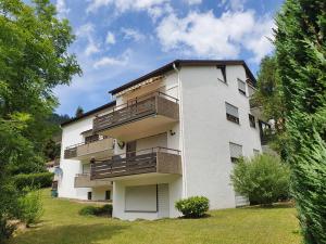 a white apartment building with balconies and a yard at Ferienwohnung Wildbad Süd in Bad Wildbad