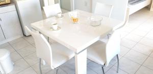 a white dining room table with white chairs at The White Apartment in Ohrid