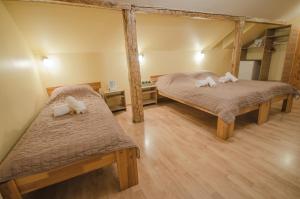 two twin beds in a room with wooden floors at Veldzes Nams in Ventspils