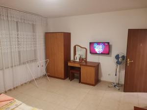 a room with a desk and a tv on a wall at Къща за гости Кадиеви in Primorsko +23 photos