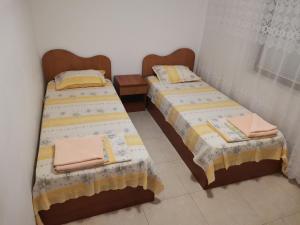 two beds sitting next to each other in a room at Къща за гости Кадиеви in Primorsko