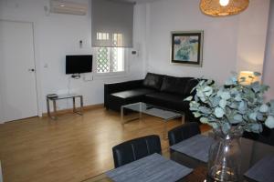 sala de estar con sofá negro y mesa en Coliseo Premium Apartment, en Sevilla