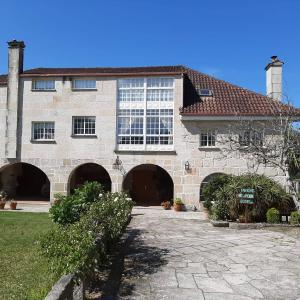 duży kamienny dom z dużym oknem w obiekcie Os Areeiros Turismo Rural & Bodega w mieście Santa Cristina de Cobres