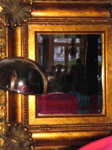 a mirror with a reflection of a bed in a room at B&B uniikki majoitus maalaisidyllissä in Tervola
