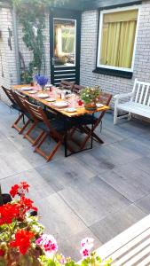 un tavolo e sedie in legno su un patio fiorito di Kreek Krak ad Arnemuiden