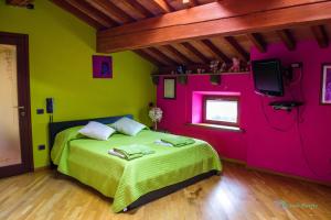 una camera con pareti rosa e verdi e un letto di Antiche Vie B&B a Serramazzoni