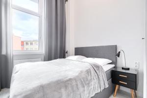 Habitación blanca con cama y ventana en Apartament 300 Apartamenty No.1 Centrum en Szczecin