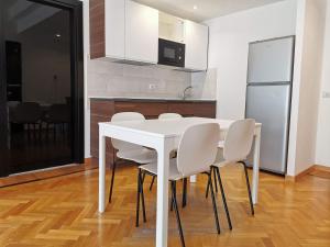 een witte eettafel met witte stoelen in een keuken bij Pergolesi Apartments in Milaan