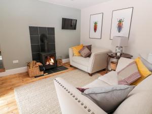 a living room with a couch and a fireplace at Yew Tree Cottage in York