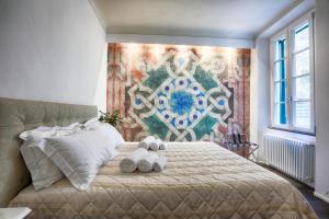Dimora storica - Palazzo del Taja في سيينا: غرفة نوم مع سرير مع اثنين من الحيوانات المحشوة عليه