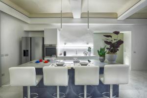 a kitchen with a table with white chairs in it at Dimora storica - Palazzo del Taja in Siena