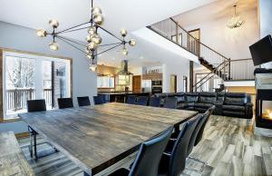 a dining room with a large wooden table and chairs at Chalet 30 Chemin des Skieurs by Chalets Alpins in Stoneham