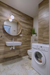 a bathroom with a washing machine and a mirror at Apartamenty Biatlonowe in Kościelisko