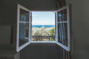 una ventana abierta con vistas al océano en Fexulis Studios & Suites en Agios Nikolaos