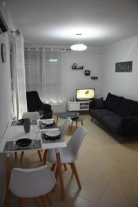 a living room with a couch and a table and chairs at Click Apartments - Tirana in Tirana