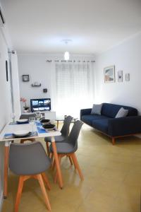 a living room with a table and a blue couch at Click Apartments - Tirana in Tirana
