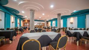 un salón de banquetes con mesas, sillas y paredes azules en Gran Hotel Mar del Plata en Mar del Plata