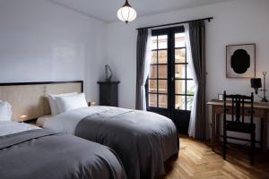 sypialnia z 2 łóżkami, biurkiem i oknem w obiekcie MARUYO HOTEL w mieście Kuwana