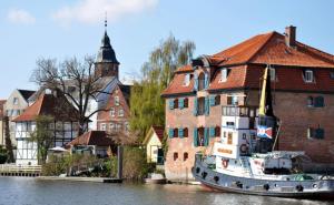 a boat sitting in the water next to a building at Stilbruch Glückstadt in Glückstadt