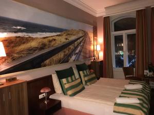 a hotel room with a bed with a painting on the wall at Stilbruch Glückstadt in Glückstadt